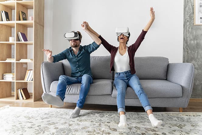 couple sur un canape avec casque VR qui s'amusent