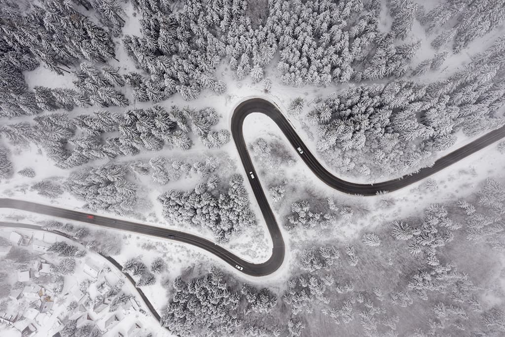 vue de drone route foret et montagne en hiver